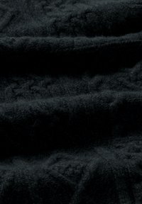 Tela de punto negra con una superficie suave y texturizada, que presenta sutiles patrones tejidos y pliegues suaves. Ideal para prendas o accesorios.