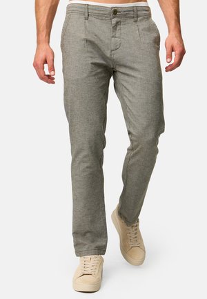 Grå, strukturerede chinos med knaplukning, skrå lommer og tapered fit, parret med beige sneakers.