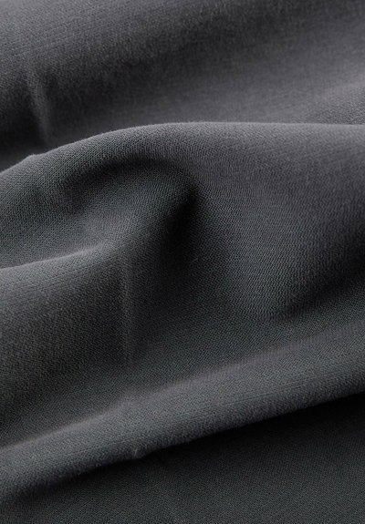 Tissu texturé, gris foncé avec une finition douce, présentant des plis lisses et fluides ainsi qu'un subtil brillant, adapté à diverses applications.