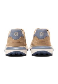 Krémové kožené tenisky s modrým semišovým podpatkem, kontrastní bílou mezipodešví a texturovanými akcenty. Obsahují logo na patě a podrážku s dobrou přilnavostí.