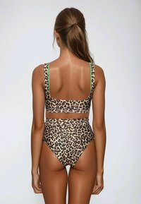 Costume da bagno leopardato, con parte inferiore a vita alta e top bralette con bretelle verdi. Tessuto liscio e design aderente.