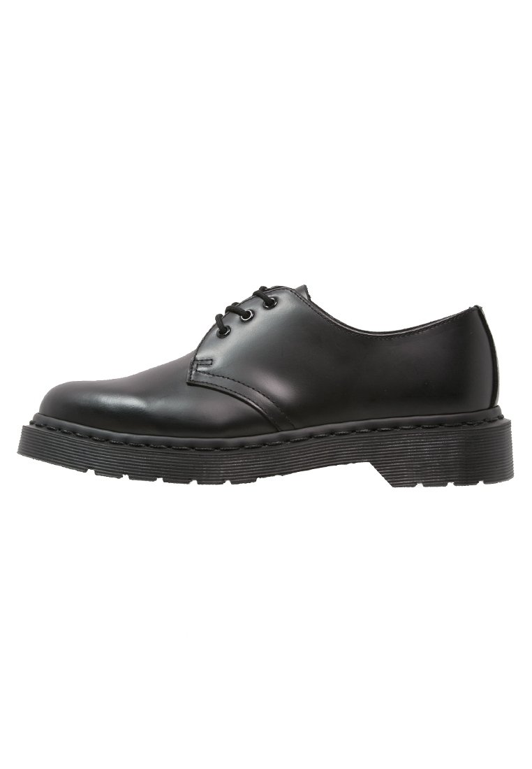 Scarpa nera in pelle con lacci, punta rotonda e suola in gomma texturizzata, caratterizzata da dettagli di cucitura lungo il bordo della suola.