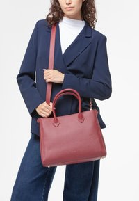 Borsa a tracolla in pelle bordeaux con doppi manici superiori, tracolla rimovibile e finitura liscia. Design rettangolare strutturato.