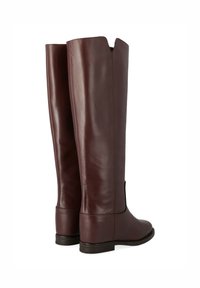 Bottes en cuir bordeaux, hautes, avec une texture lisse. Présentent une couture à l'arrière et un petit talon, ouvertes en haut avec un design fendu.