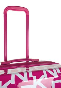 Maleta de hard-shell con un acabado brillante, predominantemente rosa con acentos gráficos blancos, que cuenta con un asa retráctil y un cierre de cremallera en la parte superior.