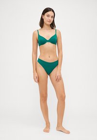 Teal bikini-set med formede kopper og justerbare stropper, samt en høy midje-bunn, laget av glatt stoff med minimal detaljering.