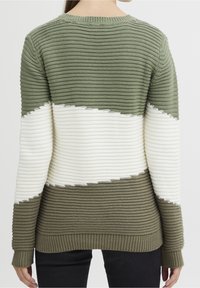 Grön och vit randig tröja med varierande texturer och ribbad nederkant. Stickad design med rund halsringning och kontrasterande färgblock.