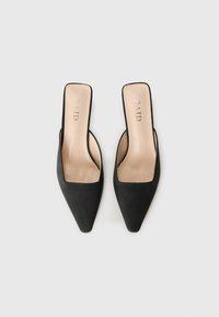 Pair of black pointed-toe slip-on heels with beige insoles, branded "RAID," on a light gray background.