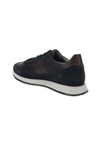 Zapatilla deportiva para hombre en azul marino, con paneles de ante y piel, suela blanca y banda de rodadura de goma negra, vista de perfil y ligeramente desde atrás.