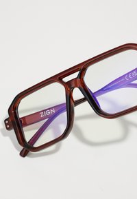Gafas de color marrón con un marco octagonal, lentes claros y un brazo interior púrpura. El nombre de la marca "ZIGN" está impreso en el interior.