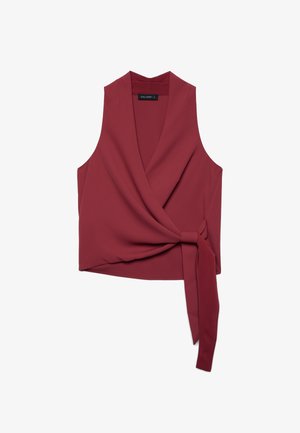 Blouse cache-cœur sans manches rouge profond avec col en V et détail de nœud latéral sur fond blanc.
