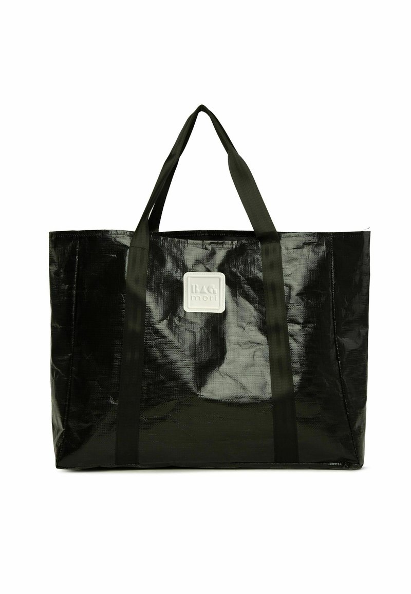 Mustaharvi kangas, joka on valmistettu kiiltävästä, tekstuurilla varustetusta materiaalista. Varusteena on kaksi kestävää kantohihnaa ja etuosassa neliömäinen brändilogo.