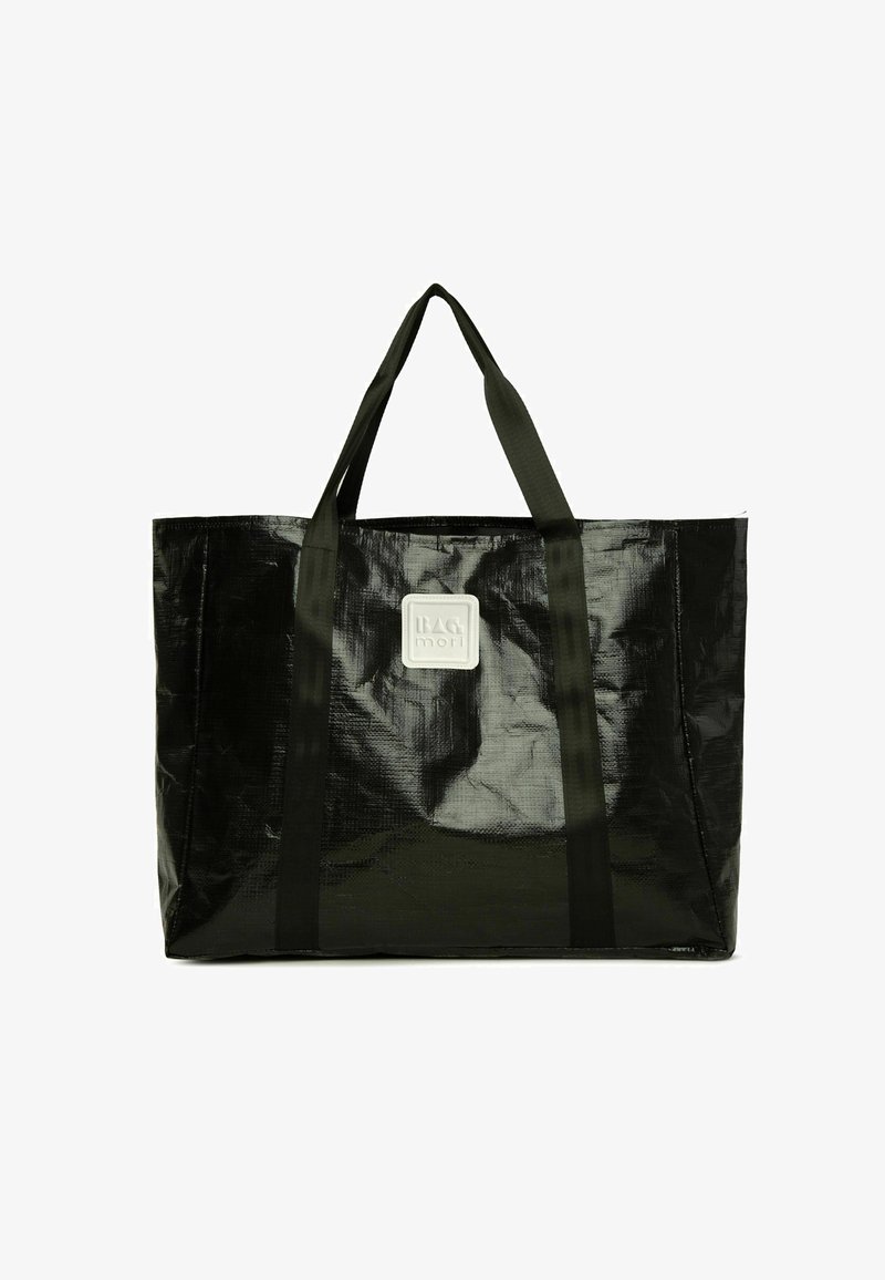 Mustaharvi kangas, joka on valmistettu kiiltävästä, tekstuurilla varustetusta materiaalista. Varusteena on kaksi kestävää kantohihnaa ja etuosassa neliömäinen brändilogo.