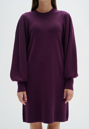 Robe pull violette avec de longues manches volumineuses et un col rond. Tissu doux avec une texture lisse, se terminant au-dessus des genoux.