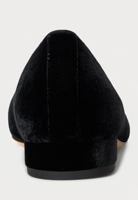 Črne balerinke iz žameta z ostrim nosom in nizko peto. Gladka tekstura z elegantnim dizajnom in minimalnimi detajli.