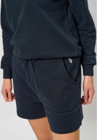 Ensemble sweat-shirt et shorts bleu marine en coton doux, avec une taille élastique à cordon, des poches latérales et un petit détail de logo.
