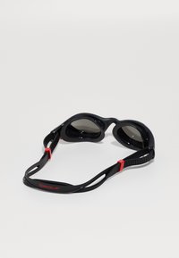 Speedo simglasögon med svarta linser, svart ram och röda detaljer. Har en flexibel rem och ergonomisk design för komfort.