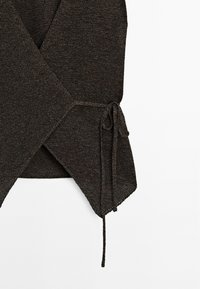 Dark brown wrap sweater made of textured knit fabric. Features a tie closure on the side and a slightly curved hemline.