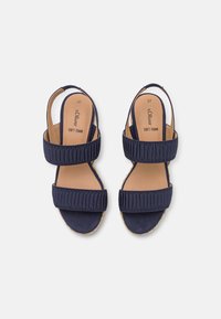Mørkeblå sandaler med to brede tekstilremmer, teksturert design og polstrede såler. Har gummisåler for grep og komfort.