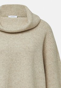 Sweter z dekoltem typu cowl w jasnym beżowym kolorze, z dzianiny o prążkowanej teksturze i szerokimi rękawami, z metką „COMMA”. 