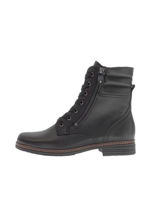 Bottine en cuir noir avec un bout rond, un laçage à l'avant, une fermeture éclair sur le côté et des détails cousus le long de la semelle. Talon bas.
