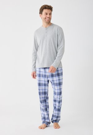 Siva potpuno dug rukav majica s tri gumba, u kombinaciji s plavim i bijelim kariranim pidžama hlačama. Mekani materijal, opušteni kroj i lagani dizajn.