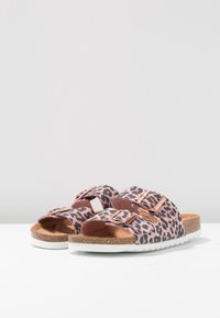 Sandały w panterkę z różową bazą, dwiema regulowanymi klamrami metalowymi oraz teksturowanym korkowym wkładem. Biała gumowa podeszwa.