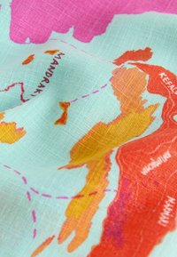 Fabric printed with a colorful map showing labeled islands and dotted travel routes on a light blue background.