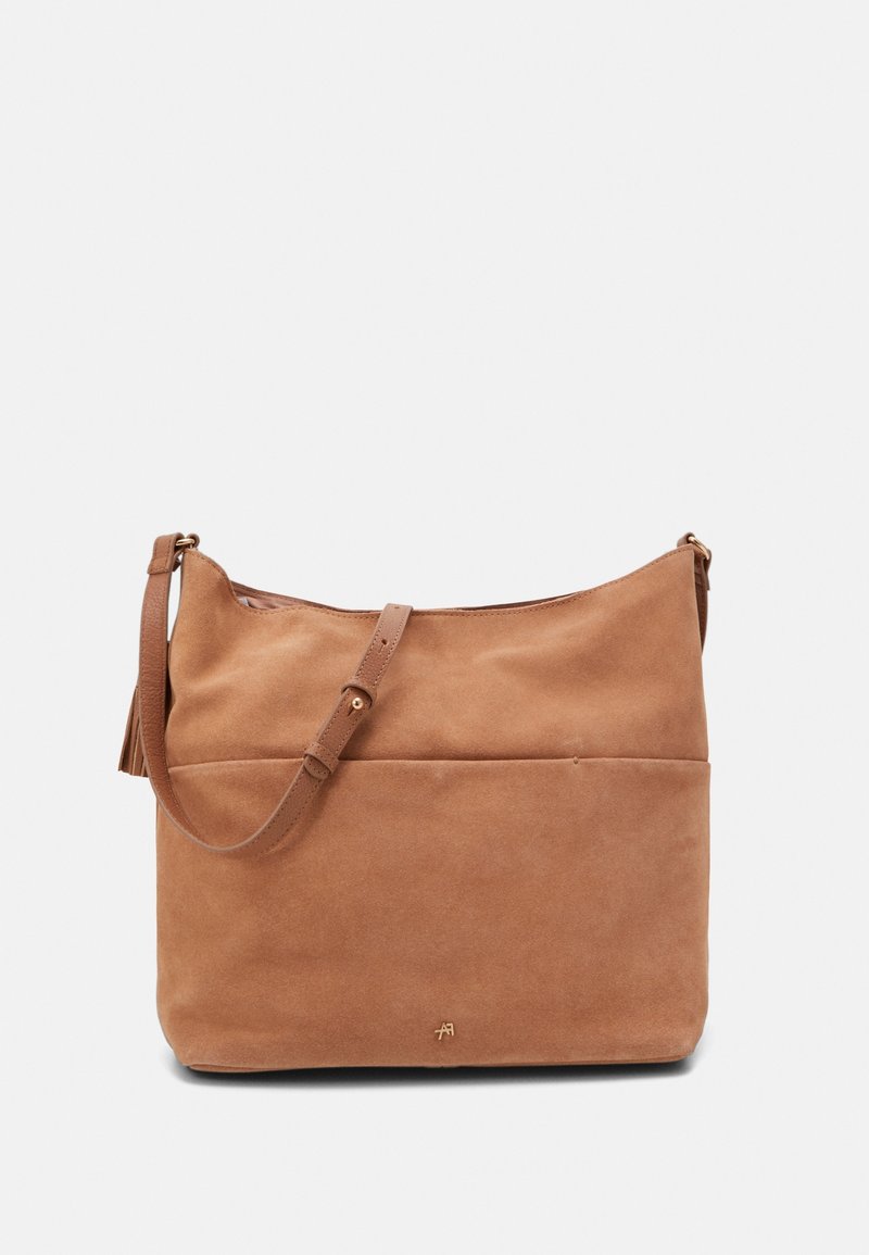 Borsa a spalla in suede beige con una singola tracolla regolabile, texture liscia, tasca frontale e dettagli logo sottili nella parte inferiore.