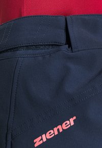 Námořnické modré sportovní šortky s texturovaným páskem, zpevněnými švy a růžovým logem Ziener na levé noze.