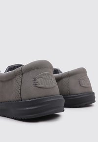 Grijze instapschoenen met een zachte textuur, voorzien van een versterkte achterkant, subtiel logo en een zwarte rubberen zool voor duurzaamheid en comfort.