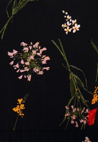 Musta kangas, jossa on kukkakuvio, jossa on vaaleanpunaisia, valkoisia, keltaisia ja punaisia kukkia vihreine varsineen. Sileä pinta, jossa yksityiskohtainen kuviointi.