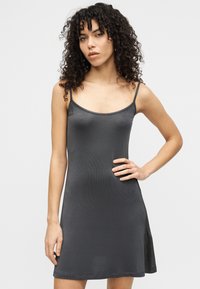 Γκρι φόρεμα τύπου τοπ, κατασκευασμένο από λείο, ελαφρύ ύφασμα. Διαθέτει λεπτές τιράντες, εφαρμοστό μπούστο και ελαφρώς φαρδιά τελείωμα. Μινιμαλιστικός σχεδιασμός.