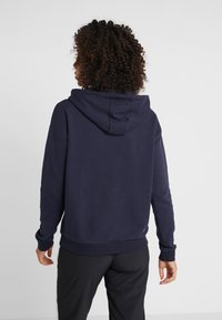 Felpa con cappuccio blu navy, con orlo aderente, cappuccio spazioso, maniche lunghe e texture morbida. Presenta un design semplice senza logo o motivi.