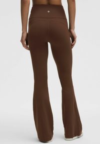 Braune ausgestellte Leggings mit hohem Bund, aus glattem, dehnbarem Stoff, mit einem Logo-Detail auf der Rückseite.