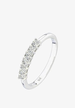 Sudraba gredzens ar sešiem apaļa griezuma caurspīdīgiem dārgakmeņiem rindā, iestiprināti plānā lokā. Iekšpusē atzīme "375" norāda zelta saturu.