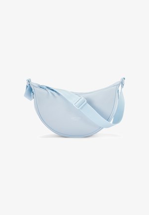 Bolsa de tela azul claro con forma redonda y creciente y correa ajustable. Presenta una textura suave y una marca sutil.