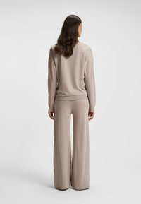 Beiges Strick-Loungewear-Set mit einem locker sitzenden Pullover mit herabgesetzten Schultern und weitem Bein. Weiche Textur und gerippte Bündchen.