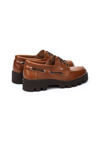 Chaussures en cuir marron avec bout rond, design avec lacets, œillets en métal, et semelle épaisse texturée comportant un talon bloc et des rainures de traction.