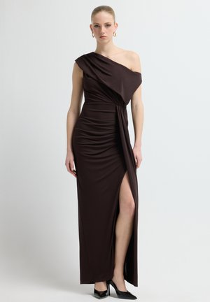 Brun one-shoulder kjole lavet af elastisk materiale, med rynkede detaljer, højt slids ved låret og et flydende design for en dramatisk silhuet.