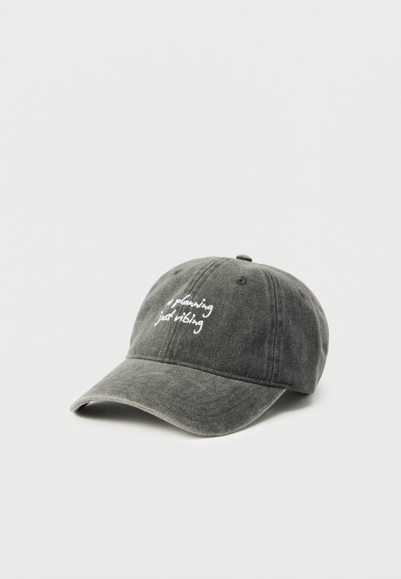 Gorra de béisbol de algodón gris con visera curvada, con texto bordado en blanco "planning just vibing" en el frente.