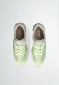 Sneakers verde chiaro realizzati in materiali mesh e scamosciati, con punta arrotondata, lacci piatti, interno imbottito e un dettaglio logo discreto.