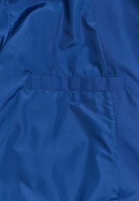 Blauwe stoffen jas met een gladde textuur en een enkele horizontale zak. Het materiaal lijkt lichtgewicht en licht glanzend.