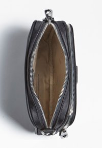 Schwarze Reißverschluss-Clutch mit glatter Außenseite, silberner Hardware und beigem Innenfutter mit dezentem Markentext.