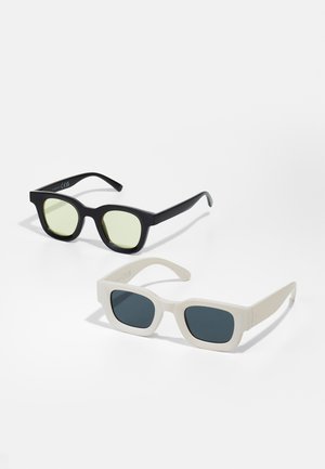 Két pár napszemüveg: az egyik fekete, világoszöld lencsékkel, téglalap alakú; a másik fehér, sötétszürke lencsékkel, négyzet alakú. Matt felület.