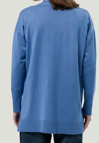 Svetr s dlouhým rukávem a otevřeným předním dílem v světle modré barvě, pletený materiál. Obsahuje žebrované manžety a lem. Hladká textura, volný střih a mírně delší zadní část.