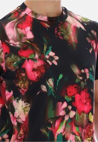 Koszulka z krótkim rękawem o czarnym tle, zdobiona żywym motywem kwiatowym w odcieniach różu, czerwieni i zieleni. Gładka tekstura i dopasowany fason.