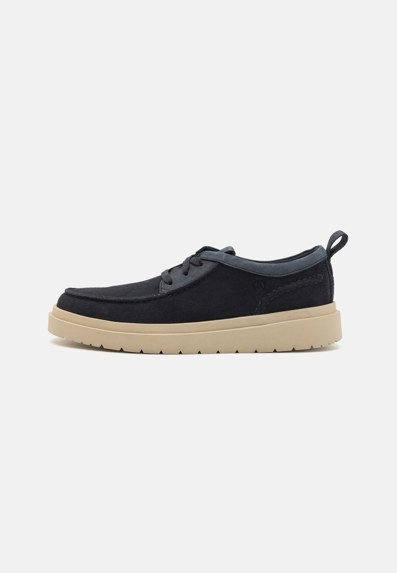 Dark navy suede shoe with a flat beige rubber sole, round toe, and lace-up design. Features a decorative stitch detail on the side.