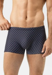 Marineblauwe boxer briefs met een herhalend cirkelpatroon in rood en wit. Gemaakt van een gladde stof, met een aansluitend ontwerp en een elastische tailleband.