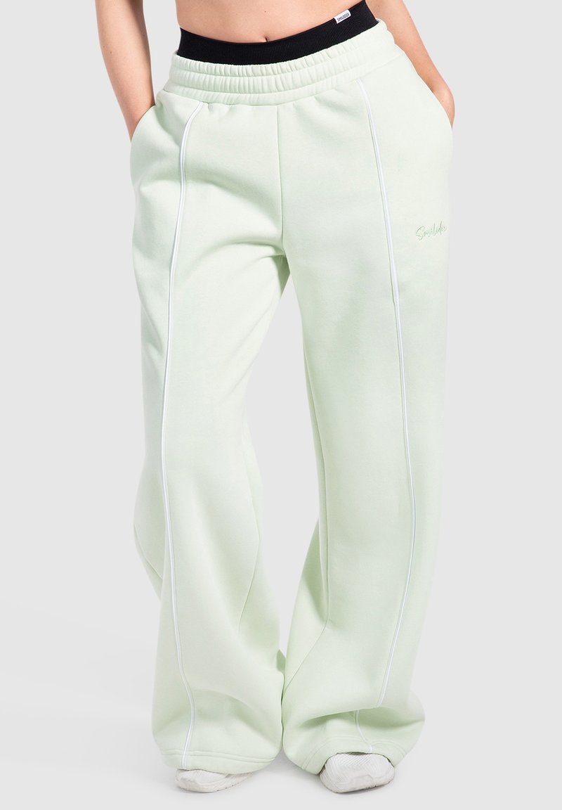 Lichtgroene joggingbroek van zachte stof met een relaxed fit, voorzien van witte piping langs de zijkanten en een elastische tailleband.